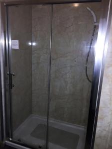 a shower with a glass door in a bathroom at Belgrave Arms Hotel in Helmsdale