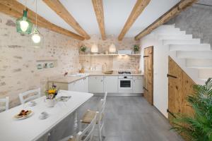 a kitchen and dining room with white cabinets and a staircase at Casa Pharus in Bale
