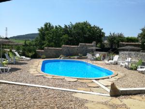 a swimming pool in a yard with chairs around it at Beeva House in Merdanya