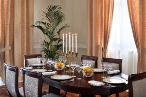 a dining room table with chairs and a table with candles at Palazzo Versace Dubai in Dubai