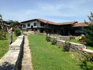 uma casa com uma parede de pedra e um quintal em Beeva House em Merdanya