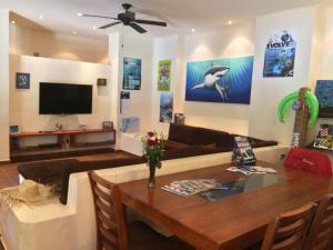 - un salon avec un canapé et une table à manger dans l'établissement La Villa Mexicana by Diving Prestige, à Xpu Ha