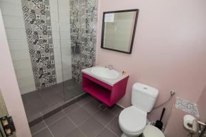 y baño con lavabo rosa y aseo. en Glam Boutique Hotel, en Eforie Nord