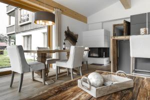 a dining room with a table and chairs and a fireplace at Ahorn Chalet Mittelberg in Mittelberg