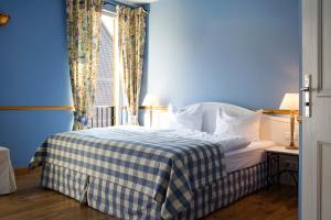 Dormitorio azul con cama y ventana en Pension La Casa dei Colori, en Weimar