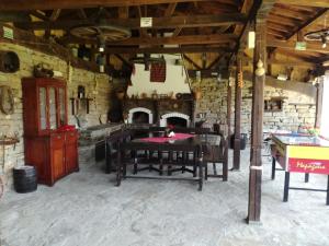 Beeva House في Merdanya: غرفة حجرية مع طاولة ومدفأة