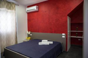 マリーナ・ディ・ラグーザにあるRegina's Homeの赤い壁のベッドルーム1室(青いベッド1台付)