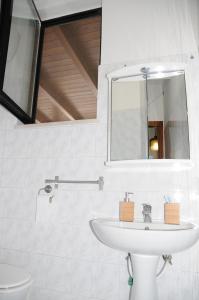 bagno bianco con lavandino e specchio di Casa Marin Marais a Bari