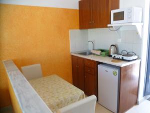 a small kitchen with a table and a microwave at Paraschos Studios Kos in Kardamaina