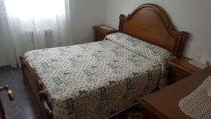 a bed with a quilt on it in a bedroom at Casa de Forno in Queijadoiro