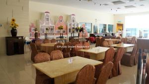 un ristorante con tavoli e sedie in una stanza di AFamosa Purple Dream Residence Condotel homestay a Malacca