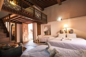 duas camas num quarto com dois cisnes em Riad Zanzibar em Marrakech