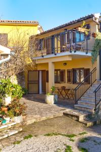 a yellow house with stairs and a balcony at Apartments Redenta in Vabriga