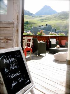 a chalkboard sign on a patio with a view of mountains at Hôtel La Vanoise in Tignes