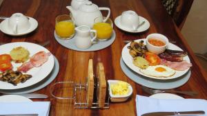 a wooden table topped with plates of breakfast food at The Boat House Bed and Breakfast in Laugharne +16 photos