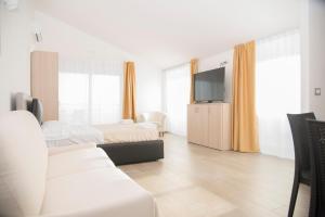 a hotel room with two beds and a flat screen tv at Santo Stefano Club in Praia a Mare
