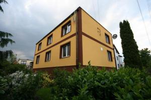 duży żółty dom z aleją w obiekcie Dom Wczasowy Aleksander w mieście Puck