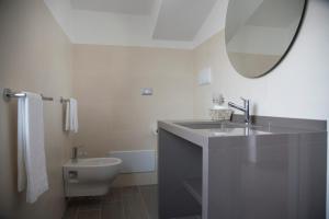a bathroom with a sink and a toilet and a mirror at Santo Stefano Club in Praia a Mare +124 photos