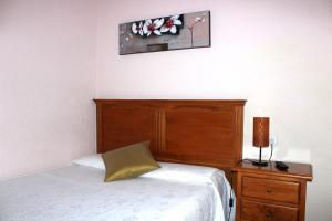 a bedroom with a bed and a wooden headboard at Hotel Oreneta in Altafulla