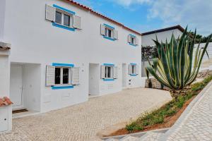 un edificio blanco con un cactus delante en 3 Villas - Praia da Falesia, en Albufeira