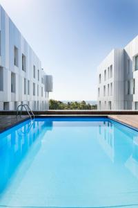 a swimming pool in front of a building at Lugaris Beach Apartments in Barcelona