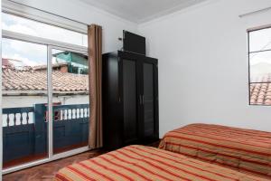 Postel nebo postele na pokoji v ubytování Hostal & Apartments El Triunfo