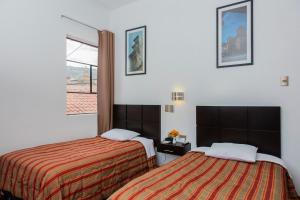 Postel nebo postele na pokoji v ubytování Hostal & Apartments El Triunfo