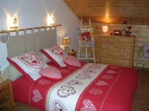 Saint-NabordにあるChalet Les Ecureuilsのベッドルーム1室(赤と白の枕が備わるベッド1台付)