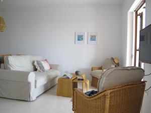 a living room with a couch and two chairs at Seafront Calista Beach House With Garden in Glyfada