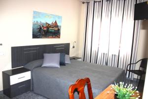 1 dormitorio con 1 cama con escritorio y una pintura en Hotel Oreneta, en Altafulla