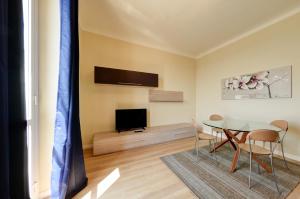 a living room with a table and a television at Blu Sea apartments in Pietra Ligure