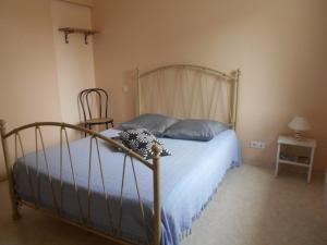 1 dormitorio con cama con sábanas azules y silla en Chez Seb & Claire, en Rorthais