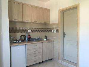 a kitchen with wooden cabinets and a sink and a door at Apartments Nurkovic in Dobra Voda +36 photos