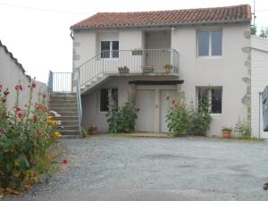 a white house with a balcony and a driveway at Chez Seb & Claire in Rorthais