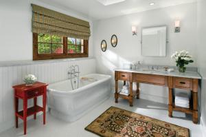 a bathroom with a tub and a sink and a bath tub at The Hermosa Inn in Phoenix