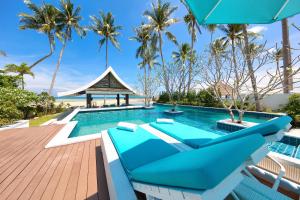 a pool at the resort with a blue couch and a gazebo at Beachfront Villa Baan Paradise in Laem Set Beach