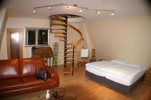 ein Wohnzimmer mit einem Bett und einer Wendeltreppe in der Unterkunft Hotel Römerhafen in Köln