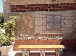 um banco sentado em frente a uma parede de tijolos em Villa Giovanna em Arenella