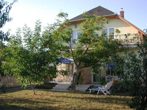 a house with a balcony and a table and chairs at Campari Panzi&oacute; in Gyenesdi&aacute;s