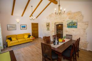 a living room with a table and a yellow couch at Casa Roza in Višnjan