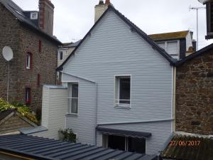 uma casa cinzenta com uma janela e um edifício de tijolos em L'Escale en Bretagne em Saint Malo