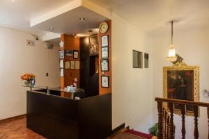 a lobby with a counter and a clock on the wall at Hostal & Apartments El Triunfo in Cusco