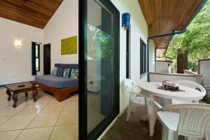 Zimmer mit einem Balkon mit einem Tisch und einem Sofa in der Unterkunft Tamarindo Blue Apartments in Tamarindo