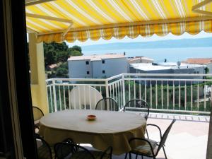 a table and chairs on a balcony with a view at Maglić Apartment in Duće