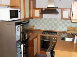a kitchen with a stove and a microwave at Maglić Apartment in Duće