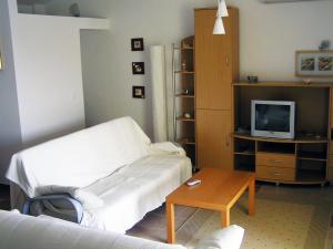 a living room with a couch and a tv and a table at Maglić Apartment in Duće +2 photos