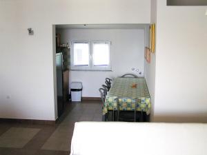 a kitchen with a table and chairs in a room at Maglić Apartment in Duće