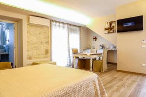 a room with a bed and a table and a kitchen at B&B Dei Raselli in Guardiagrele