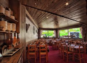 a dining room with wooden tables and chairs at Hotel Le Pelvoux in Les Menuires