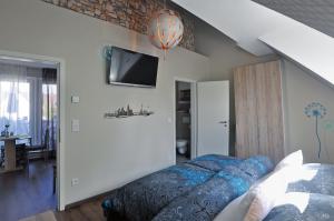 um quarto com uma cama e uma televisão na parede em Frankfurt Bed & Breakfast em Frankfurt